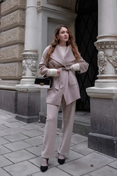 a lady in a light pink coat and a pair of knit pants